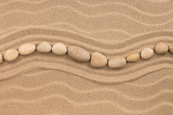 Lijn gemaakt van witte stenen golvende, liggend op zandduin. — Stockfoto