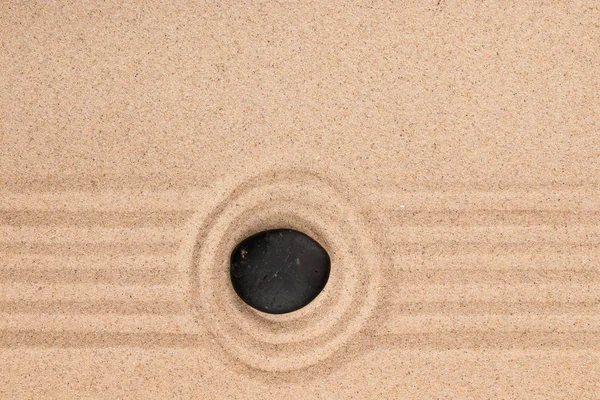 Чорний камінь лежить в центрі кола з піском. Літня концепція . — стокове фото