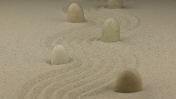 Inzoomen. Witte stenen liggend op het zand zigzag. — Stockvideo