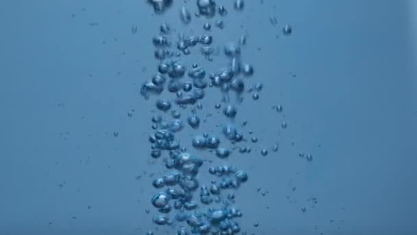 Au ralenti. Mouvement abstrait des bulles d'air sous l'eau. Bulles d'air tourbillonnantes jet dans l'eau bleue. Gros plan . — Video