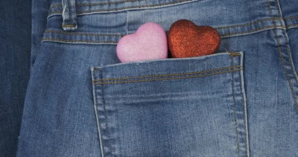 全景。两只象征性的心从牛仔裤的后面口袋里伸出来，特写。情人节. — 图库视频影像