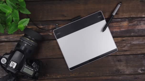 Benadering ontwerpers achtergrond, focus op de stylus liggend op een grafische tablet. Bovenaanzicht. — Stockvideo