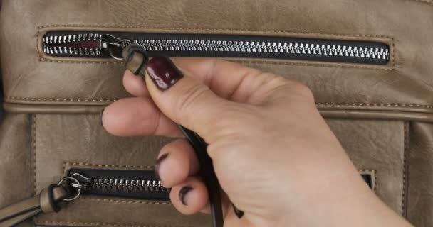 Hand opens the lock with a zipper, a pocket of a brown women bag. Close-up — Stok video