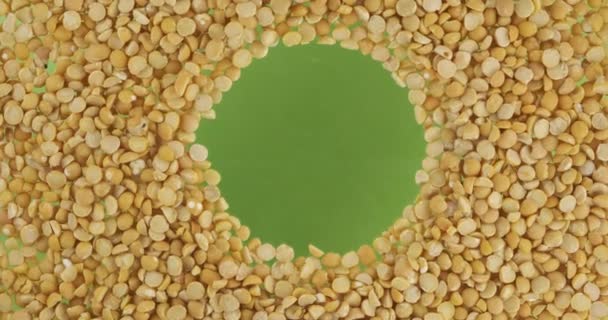Rotación de granos de guisantes dispersos en un círculo con espacio en el centro. Vista superior . — Vídeo de stock
