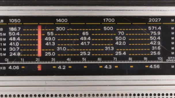 Sintonizando la frecuencia de la estación de radio en la vieja radio. La flecha roja se mueve en una escala con números . — Vídeos de Stock