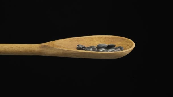 Le tournesol à graines tombantes remplit la cuillère et tombe d'une cuillère en bois. Mouvement lent . — Video