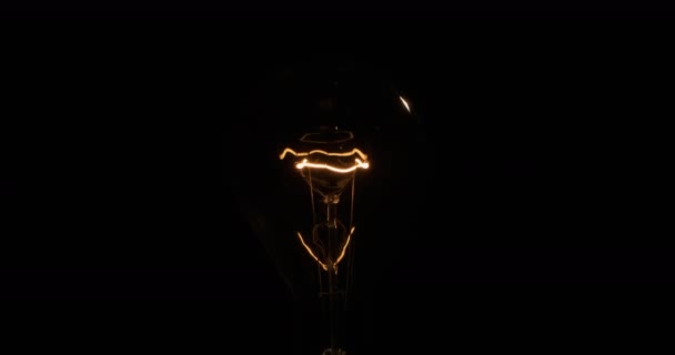 Knipperende spiraal van een oude lamp. Wolfraam gloeidraad op een zwarte achtergrond. — Stockvideo
