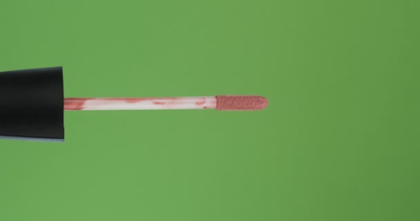 Horizontal rotation of the brush, lip gloss, on a green screen. Close-up. — Stock Video