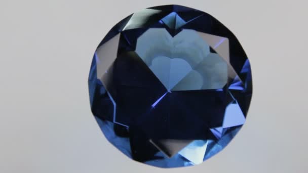 Rotation av en stor blå diamant på en vit bakgrund. Ovanifrån. — Stockvideo