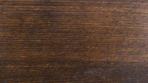 Au ralenti. Des gouttes simples coulent sur une surface en bois brun . — Video