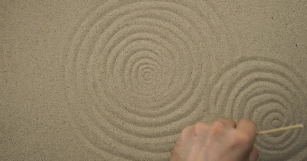 Dessin avec un bâton sur le sable. Cercles concentriques abstraits. Contexte symbolique . — Video