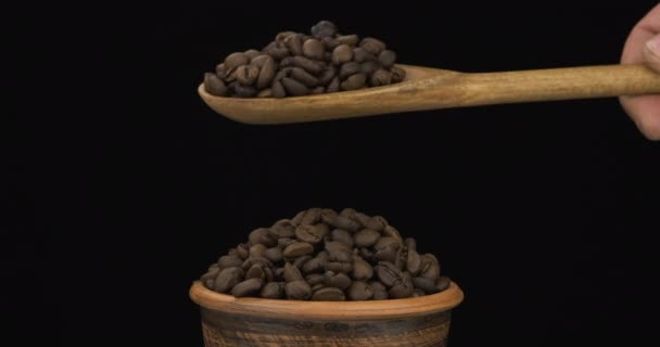 Koffiebonen krijgen genoeg slaap van een houten lepel op een stapel zaad in een kleikom. — Stockvideo
