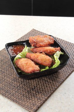 Soslu ve sebzeli kızarmış tavuk kanadı.