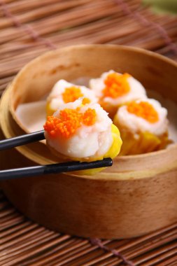 closeup of steamed dumplings in  bamboo steamer - dim sum