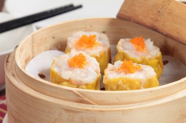closeup of steamed dumplings in  bamboo steamer - dim sum