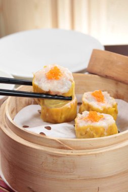closeup of steamed dumplings in  bamboo steamer - dim sum