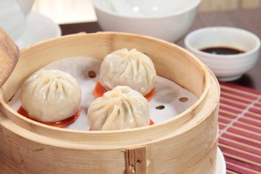 closeup of steamed dumplings in  bamboo steamer - dim sum