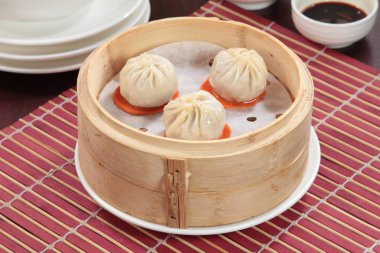 closeup of steamed dumplings in  bamboo steamer - dim sum