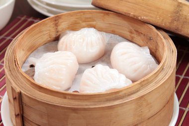 closeup of steamed dumplings in  bamboo steamer - dim sum