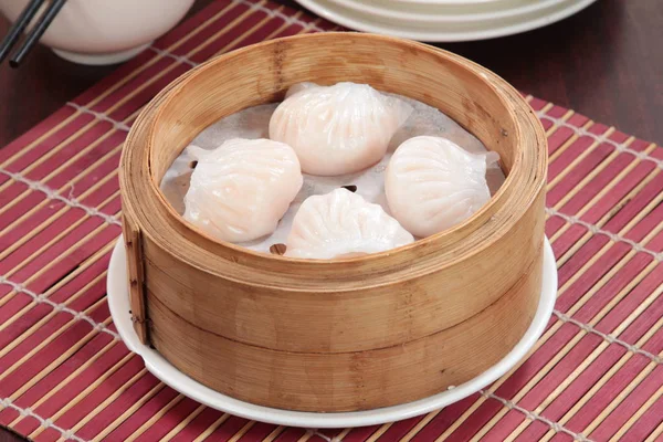closeup of steamed dumplings in  bamboo steamer - dim sum