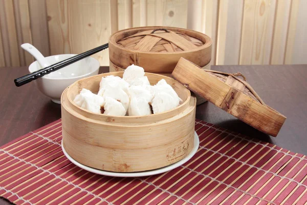 closeup of steamed dumplings in  bamboo steamer - dim sum