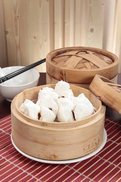 closeup of steamed dumplings in  bamboo steamer - dim sum