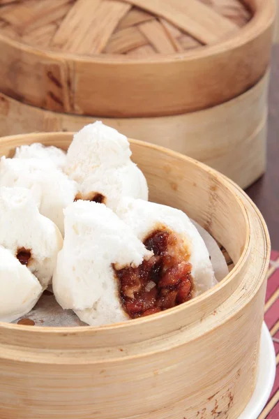 closeup of steamed dumplings in  bamboo steamer - dim sum