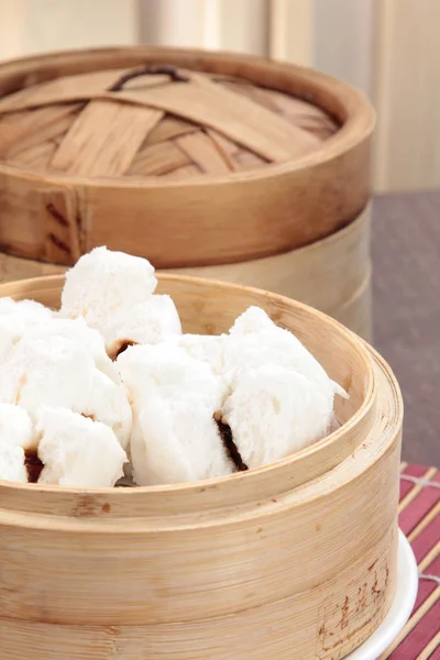 closeup of steamed dumplings in  bamboo steamer - dim sum