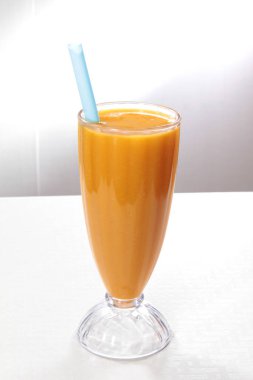 Beyaz arka planda cam kaplı taze mango smoothie.