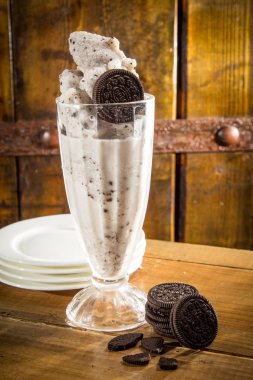 chocolate ice cream with whipped seeds and mint on wooden background