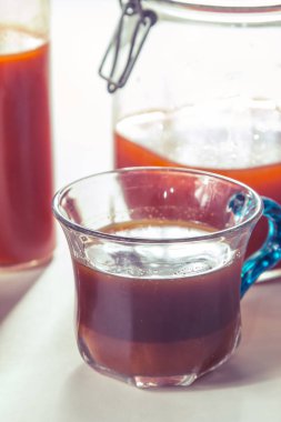 close up of a glass of red wine with a cup of tea