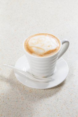 Beyaz arka planı olan bir fincan kapuçino.