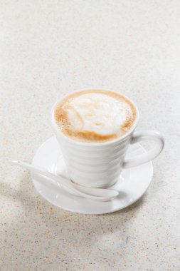 Beyaz arka planı olan bir fincan kapuçino.