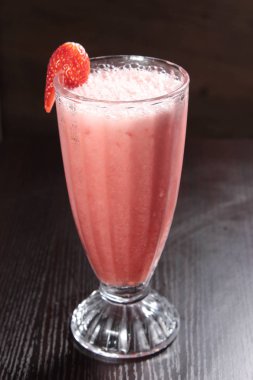 strawberry smoothie with fresh strawberries and mint on a dark background