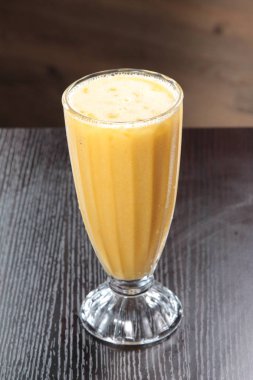 fresh mango juice in a glass on a wooden background