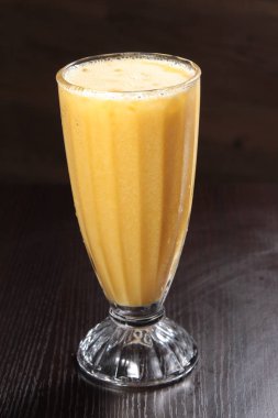 fresh mango juice in a glass on a wooden background