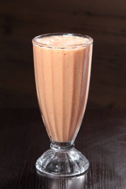 delicious milkshake with chocolate and banana on wooden background
