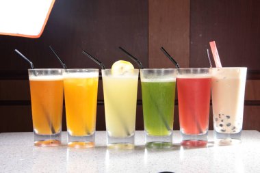 Tahta bir masada bardakta taze meyve suyu.