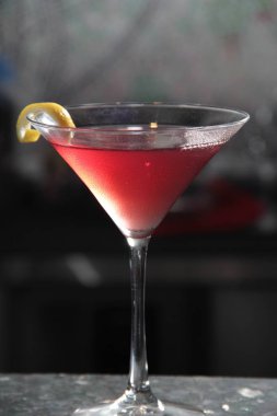 red alcoholic cocktails in a restaurant with ice and green olives, black background with a cocktail, close-
