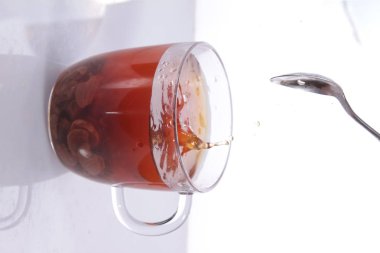 a glass of milk and a spoon with a red handle on a white background