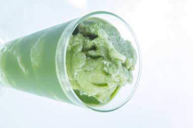 green matcha ice cream in a glass bowl on white background
