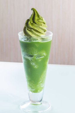 Beyaz arka planda cam bardakta yeşil içecek.