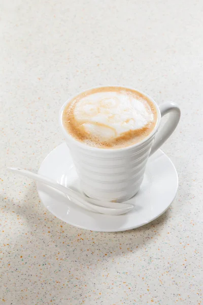 Beyaz arka planı olan bir fincan kapuçino.
