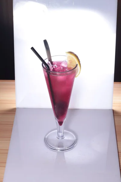Een Glas Cocktail Met Ijs Een Rode Achtergrond — Stockfoto