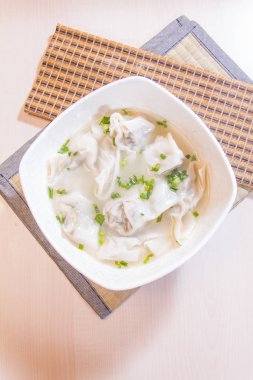 closeup of chinese dumplings in soup