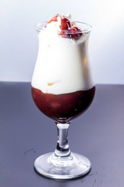 glass of tasty ice cream with whipped milk and chocolate on white background