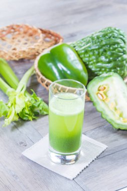 Taze kereviz ve ahşap arka planda yeşil biberli yeşil smoothie.