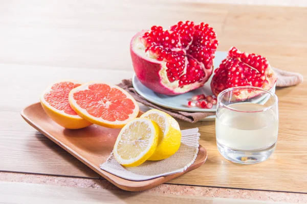 Closeup Pomegranate Grapefruit Lemon Glass Water Wooden Table — Zdjęcie stockowe