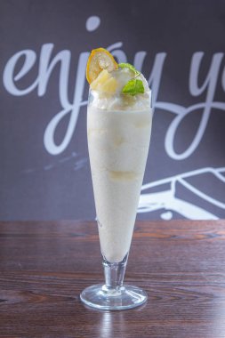 Arka planda çırpılmış süt ve limonlu dondurma.