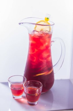 Beyaz arka planda bir bardak taze kırmızı limonata.